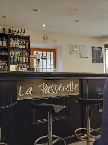 Comptoir du bar intérieur de La Passerelle avec son enseigne en bois
