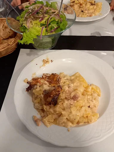 Tartiflette maison servie avec salade verte et corbeille de pain